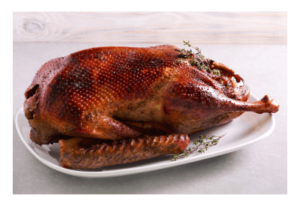 A roast goose on a white platter