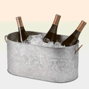 Three bottles of wine chilling in ice in a silver wine trough