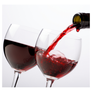 Two glasses of red wine, one being poured from a bottle