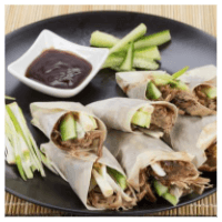 Some duck and cucumber in Chinese pancakes on a plate with a bowl of plum sauce