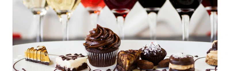 A selection of small chocolate desserts with glasses of different wines