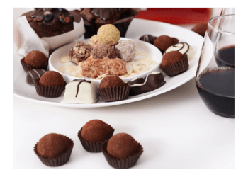 A plate of chocolate truffles and glasses of red wine