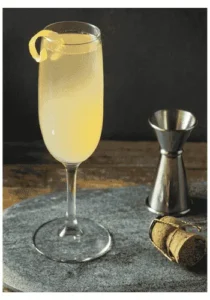Glass of French 75 cocktail, lemon sugar syrup and champagne