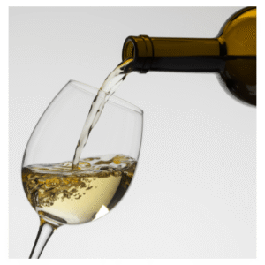 Glass of white wine being poured from a botttle