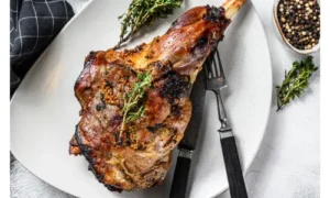 A cooked leg of lamb on a white platter