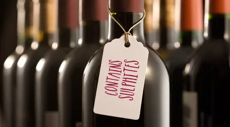 Bottles of red wine, one with tag reading "Contains Sulphites"