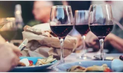 Table laden with plates of barbecue food and wine glasses