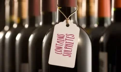 Bottles of red wine, one with tag reading "Contains Sulphites"